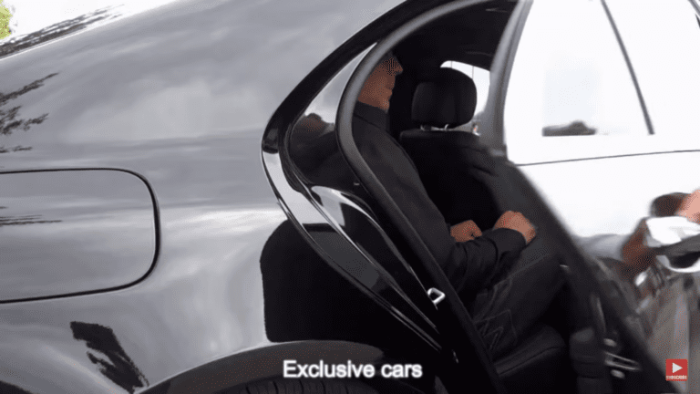 Customer being seated in rear of black luxury sedan